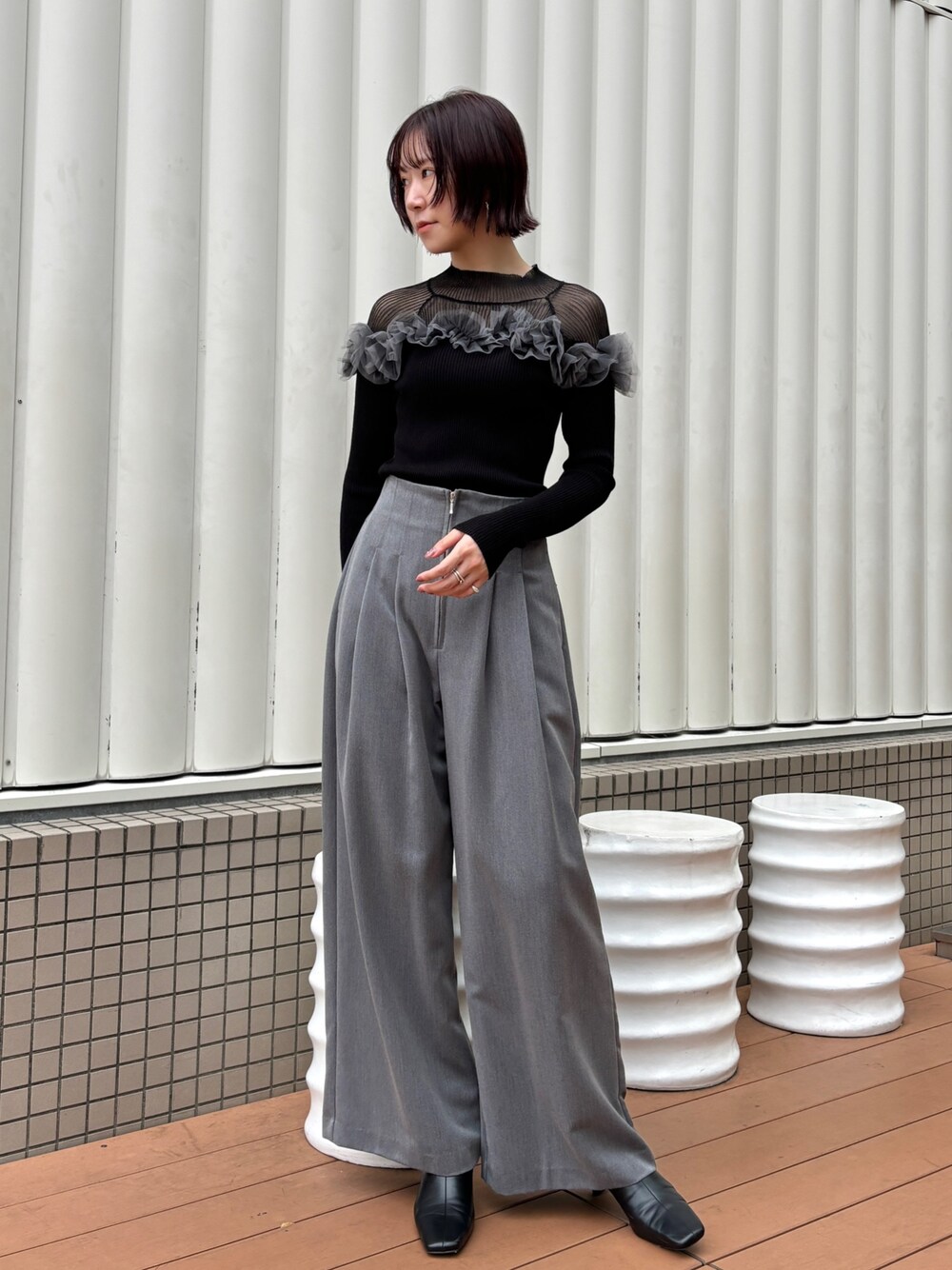 グレー系のその他パンツ、ブラック系のニット/セーター、ブラック系のブーツを着用したレディースの秋コーディネートの1枚目の写真