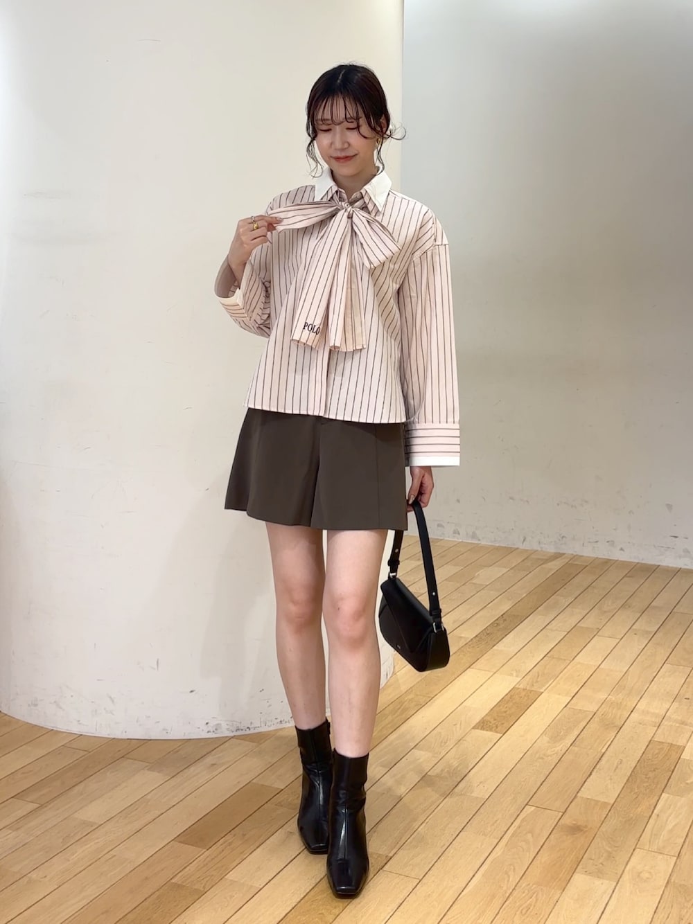 ブラウン系のその他パンツ、ブラック系のブーツ、ブラック系のハンドバッグを着用したレディースの夏コーディネートの1枚目の写真