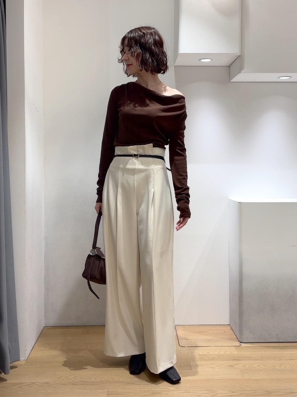ホワイト系のその他パンツ、ブラウン系のニット/セーター、ブラウン系のハンドバッグを着用したレディースの秋コーディネートの1枚目の写真