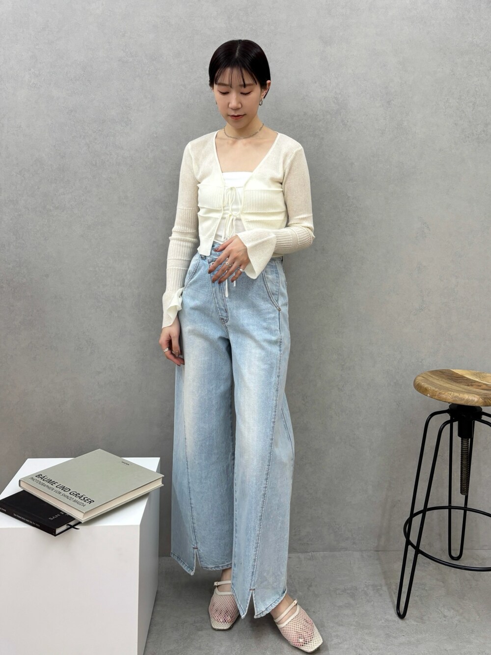 ブルー系のデニムパンツ、ホワイト系のカーディガン/ボレロ、ホワイト系のサンダルを着用したレディースの春コーディネートの1枚目の写真