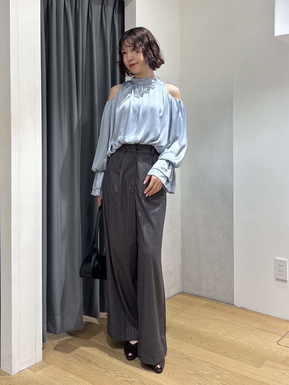 ブルー系のシャツ/ブラウス、グレー系のその他パンツ、ブラック系のハンドバッグを着用したレディースの秋コーディネートの1枚目の写真