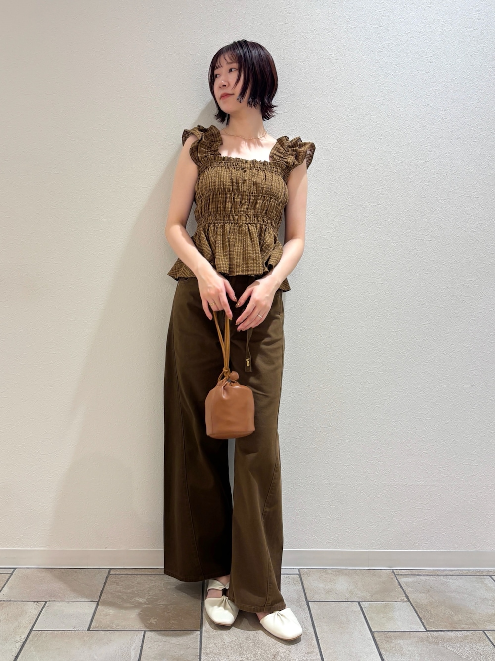 イエロー系のハンドバッグ、ブラウン系のデニムパンツ、ブラウン系のシャツ/ブラウスを着用したレディースの夏コーディネートの1枚目の写真