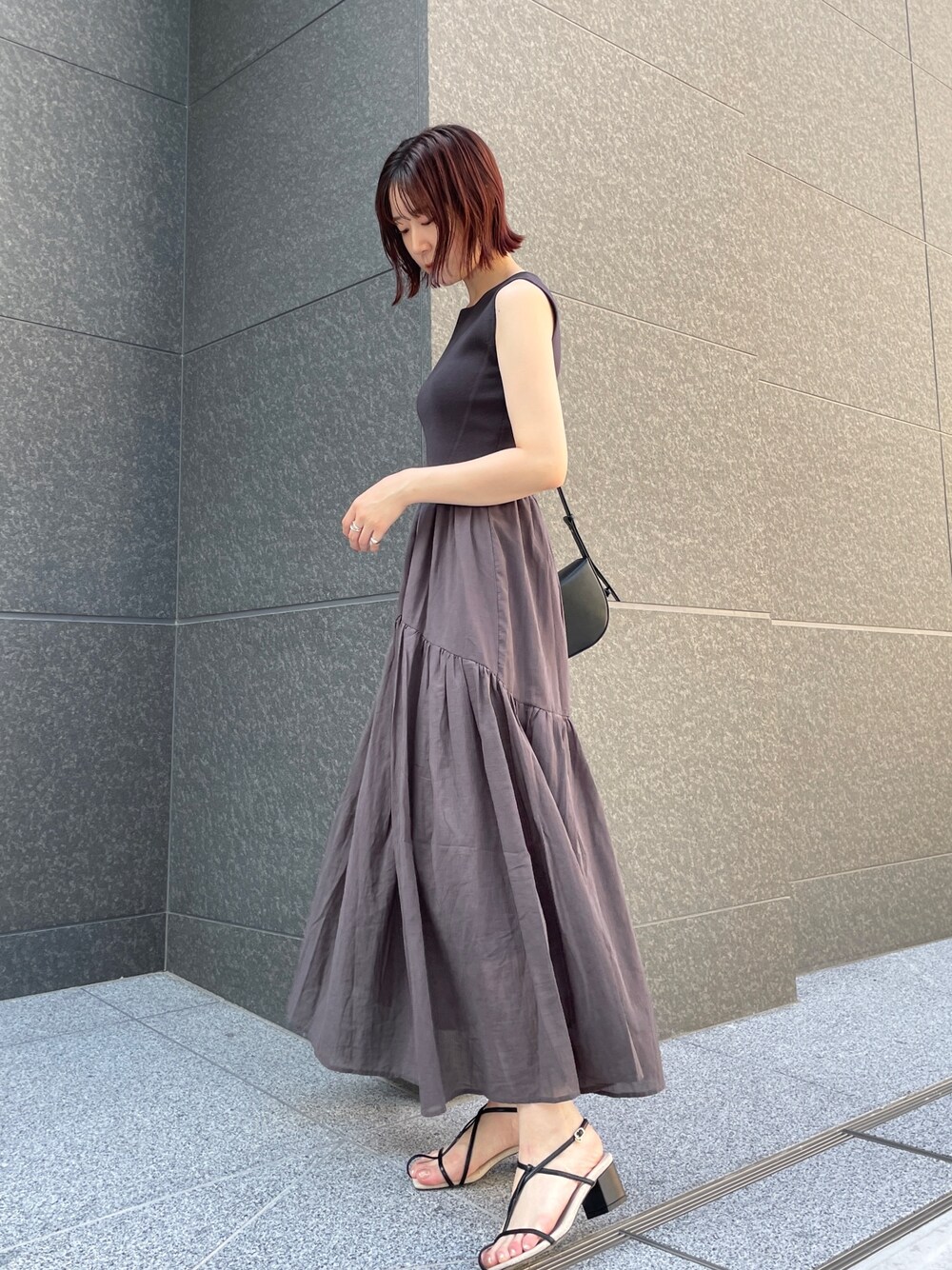 ブラック系のサンダル、グレー系のワンピース、ブラック系のショルダーバッグを着用したレディースの夏コーディネートの1枚目の写真