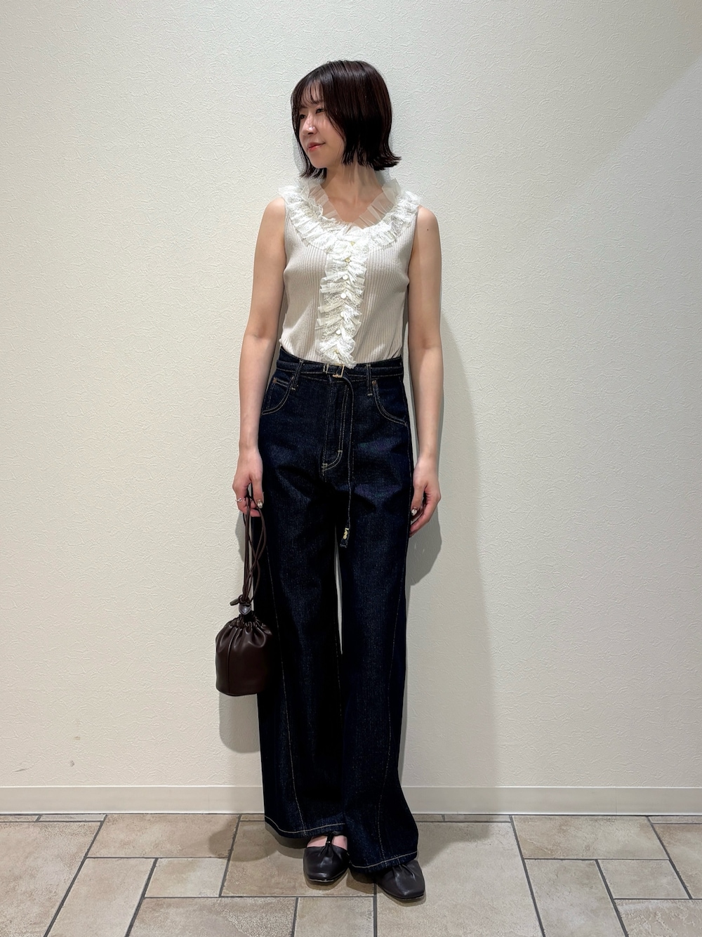 ベージュ系のニット/セーター、ブルー系のデニムパンツ、ブラウン系のサンダルを着用したレディースの夏コーディネートの1枚目の写真