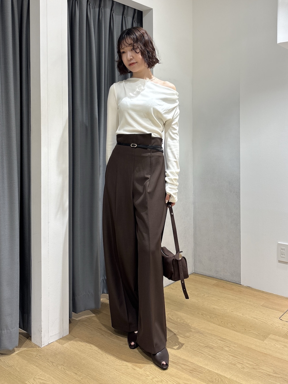 ブラウン系のその他パンツ、ホワイト系のニット/セーター、ブラウン系のハンドバッグを着用したレディースの秋コーディネートの1枚目の写真
