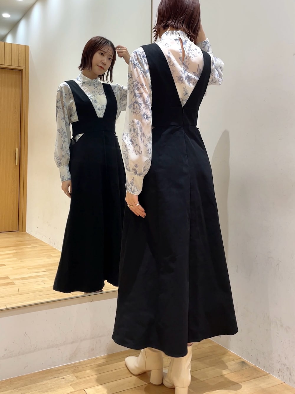 ホワイト系のブーツ、ブルー系のシャツ/ブラウス、ブラック系のジャンパースカートを着用したレディースの冬コーディネートの1枚目の写真