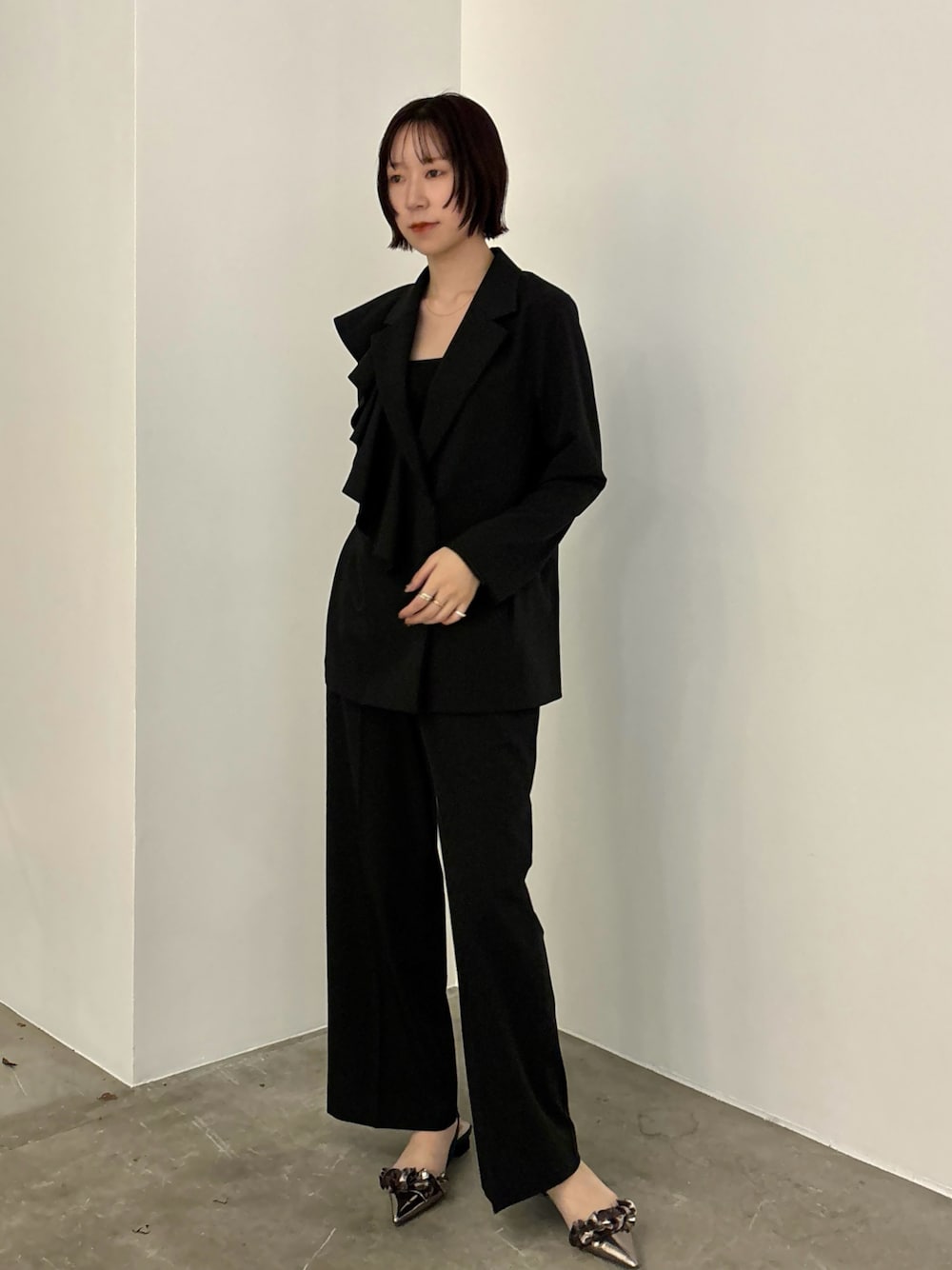 ブラック系のテーラードジャケット、その他のパンプス、ブラック系のスラックスを着用したレディースの冬コーディネートの1枚目の写真