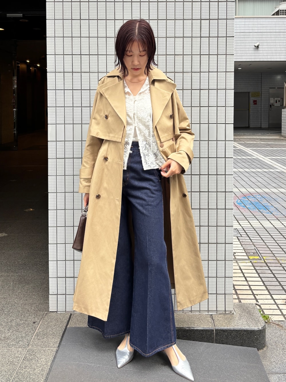 ブルー系のデニムパンツ、ベージュ系のトレンチコート、ホワイト系のシャツ/ブラウスを着用したレディースの冬コーディネートの1枚目の写真