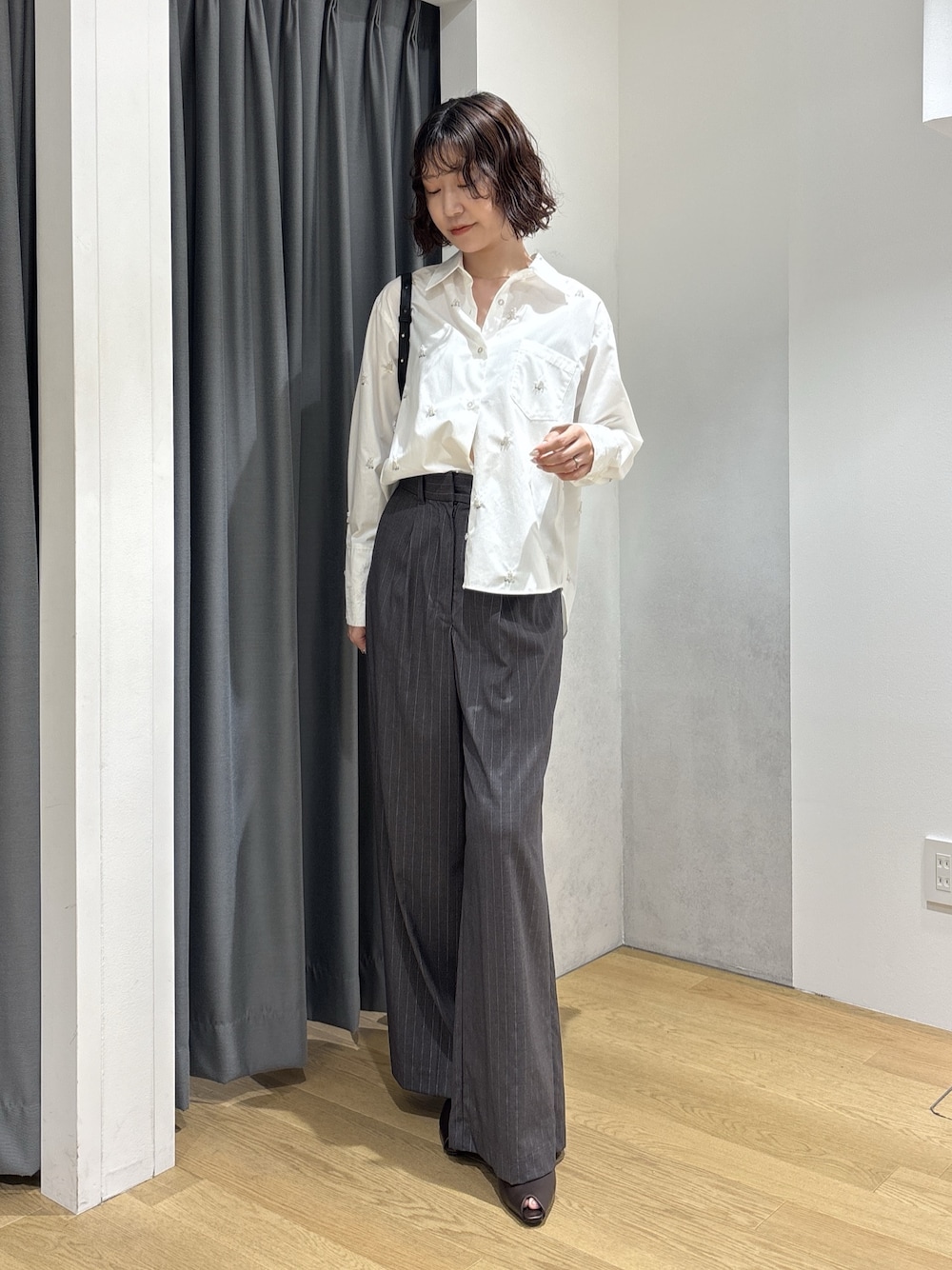 グレー系のその他パンツ、ホワイト系のシャツ/ブラウス、ブラック系のハンドバッグを着用したレディースの秋コーディネートの1枚目の写真
