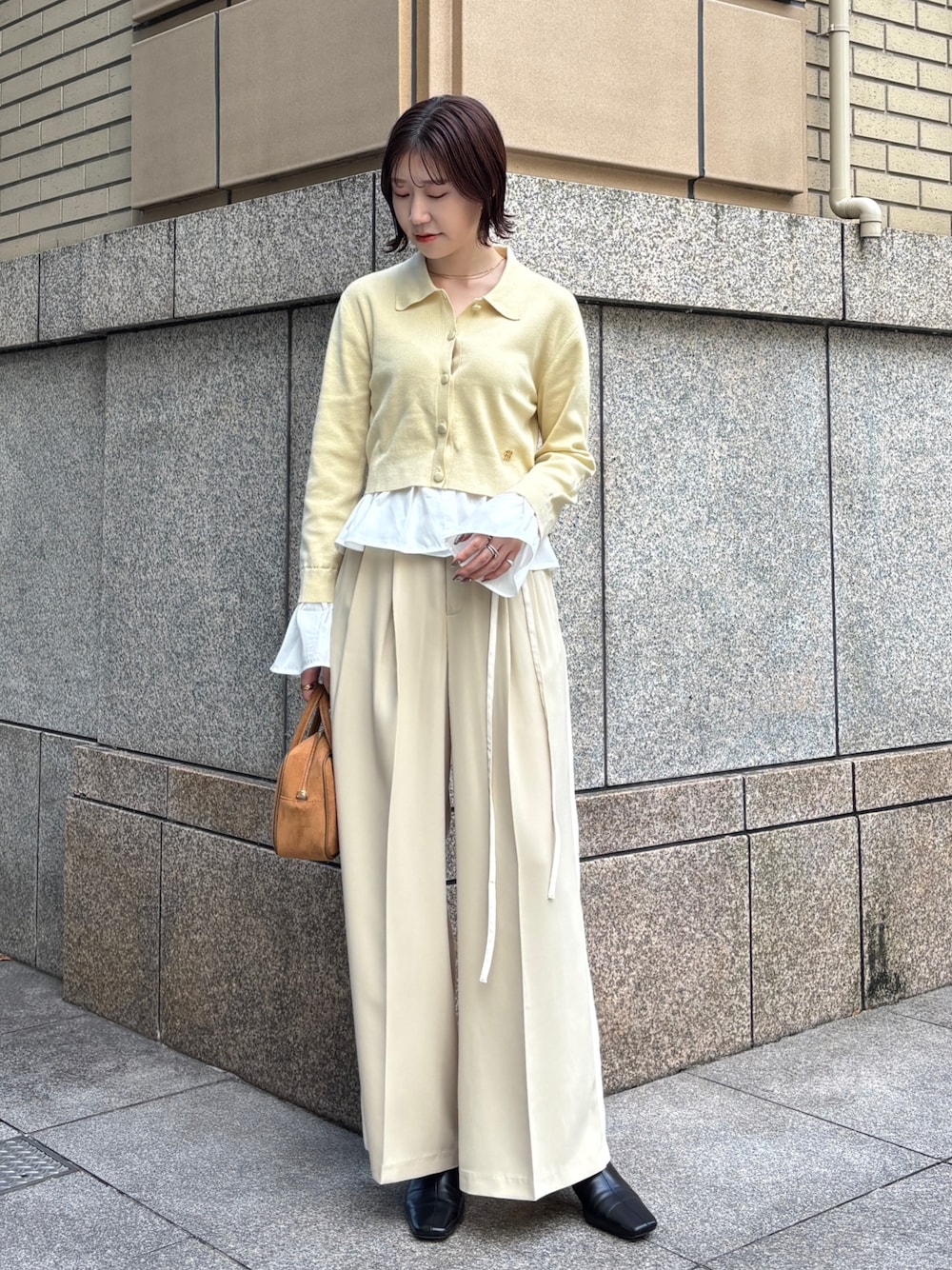 ベージュ系のその他パンツ、イエロー系のハンドバッグ、イエロー系のカーディガン/ボレロを着用したレディースの秋コーディネートの1枚目の写真