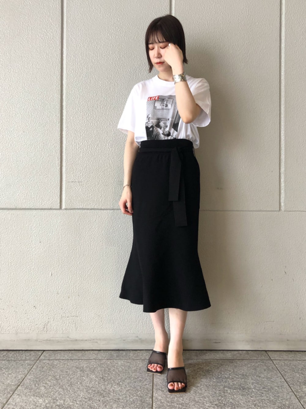 ブラック系のスカート、ブラック系のその他シューズ、ホワイト系のTシャツ/カットソーを着用したレディースの夏コーディネートの1枚目の写真