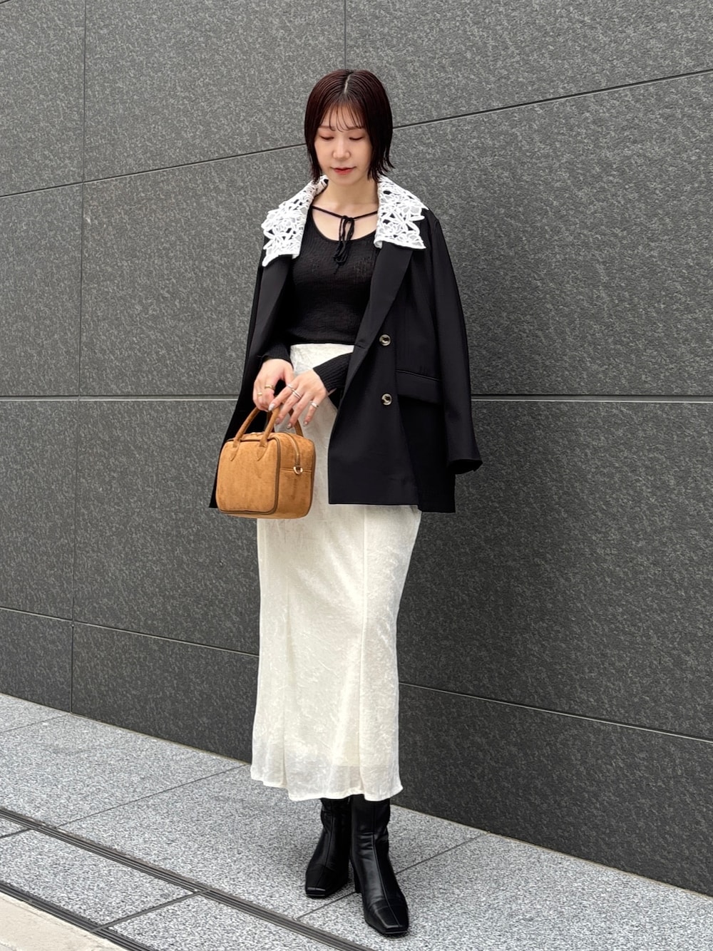 ホワイト系のスカート、イエロー系のハンドバッグ、ブラック系のブーツを着用したレディースの秋コーディネートの1枚目の写真