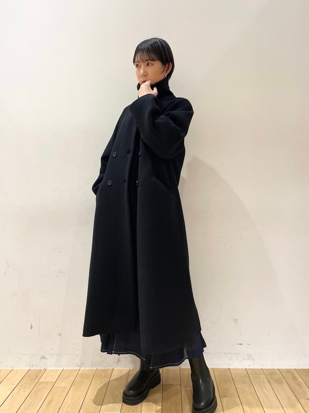 ブラック系のその他アウター、ホワイト系のニット/セーター、ブルー系のスカートを着用したレディースの冬コーディネートの1枚目の写真