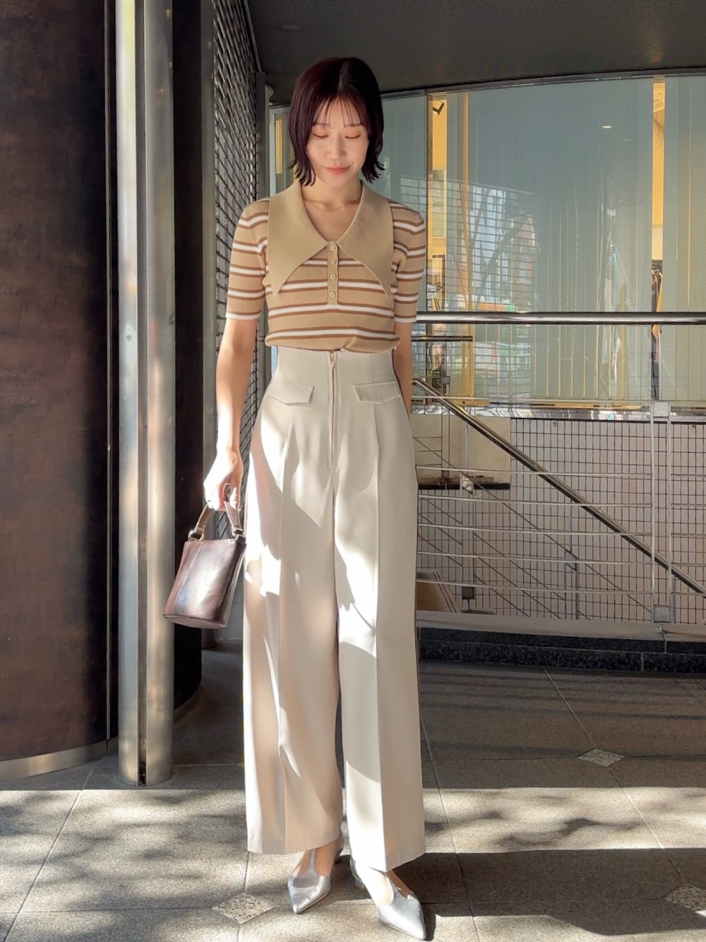 ホワイト系のその他パンツ、シルバー系のパンプス、ブラウン系のハンドバッグを着用したレディースの冬コーディネートの1枚目の写真