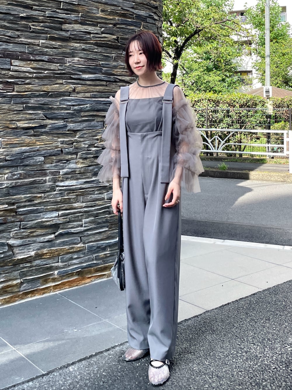 グレー系のその他パンツ、グレー系のシャツ/ブラウス、ブラック系のハンドバッグを着用したレディースの秋コーディネートの1枚目の写真