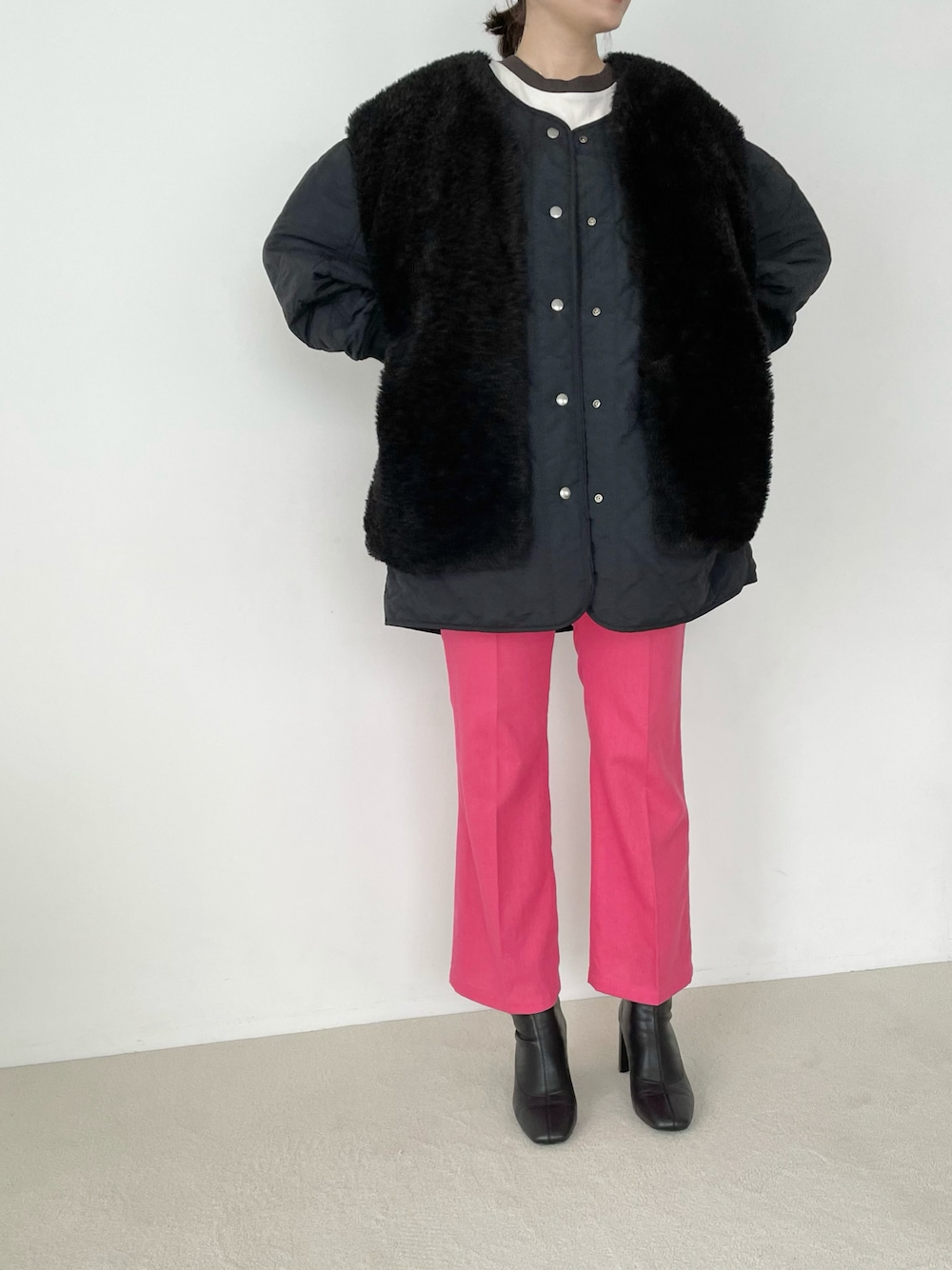 ブラック系のブルゾン、ピンク系のスラックス、ブラック系のブーツを着用したレディースの夏コーディネートの1枚目の写真