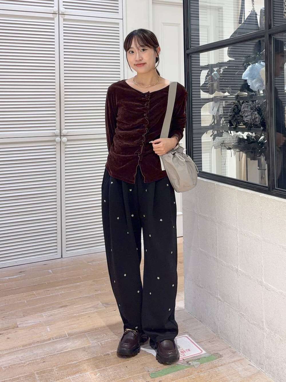 グレー系のショルダーバッグ、ブラック系のスウェットパンツ、ブラウン系のTシャツ/カットソーを着用したレディースの秋コーディネートの1枚目の写真