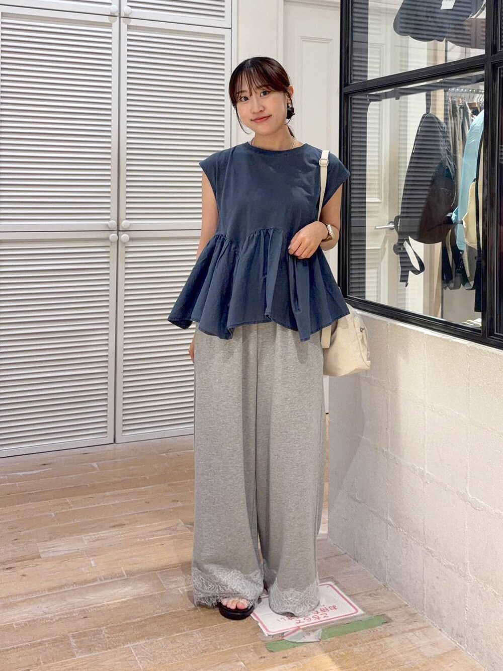 ブルー系のTシャツ/カットソー、ブラック系のサンダル、グレー系のスウェットパンツを着用したレディースの夏コーディネートの1枚目の写真