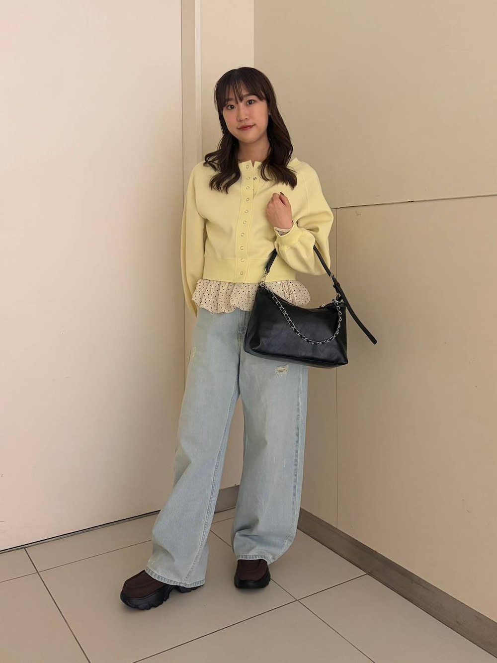 ブルー系のデニムパンツ、ブラック系のショルダーバッグ、ブラウン系のローファーを着用したレディースの春コーディネートの1枚目の写真