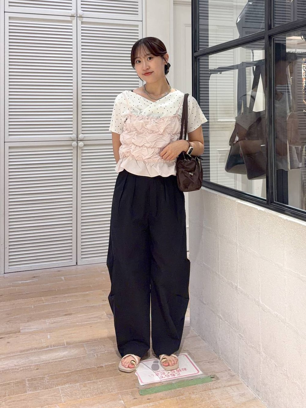 ピンク系のベスト、ブラック系のその他パンツ、ベージュ系のTシャツ/カットソーを着用したレディースの夏コーディネートの1枚目の写真