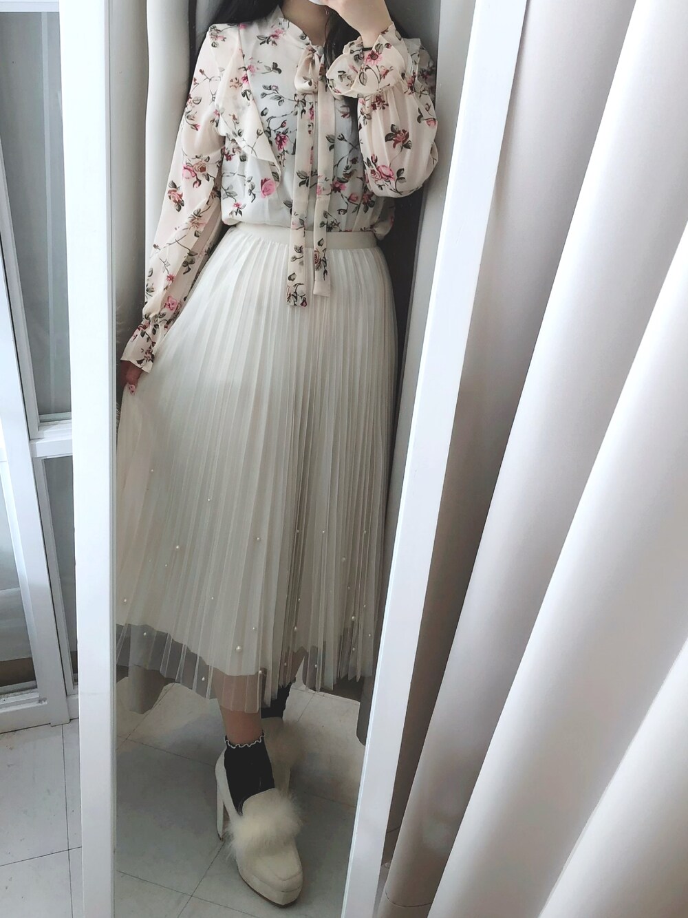 ホワイト系のスカート、ベージュ系のローファーを着用したレディースの冬コーディネートの1枚目の写真