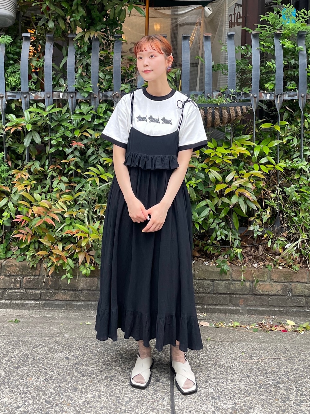 ブラック系のスカート、ホワイト系のTシャツ/カットソー、グレー系のサンダルを着用したレディースの春コーディネートの1枚目の写真