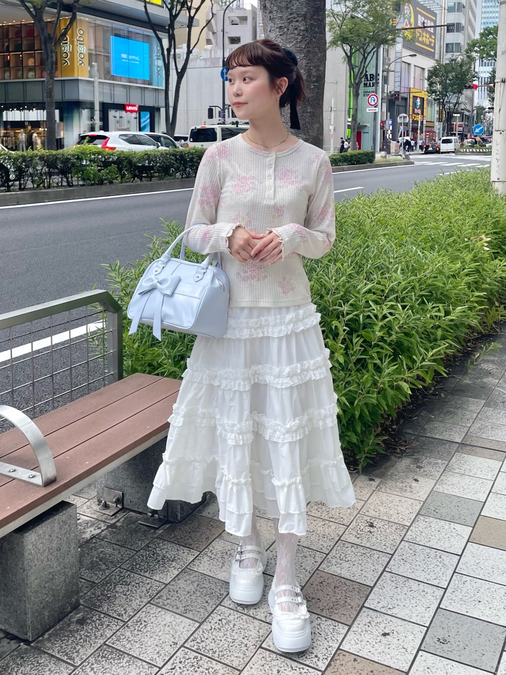 ピンク系のTシャツ/カットソー、ホワイト系のスカート、ブルー系のハンドバッグを着用したレディースの秋コーディネートの1枚目の写真