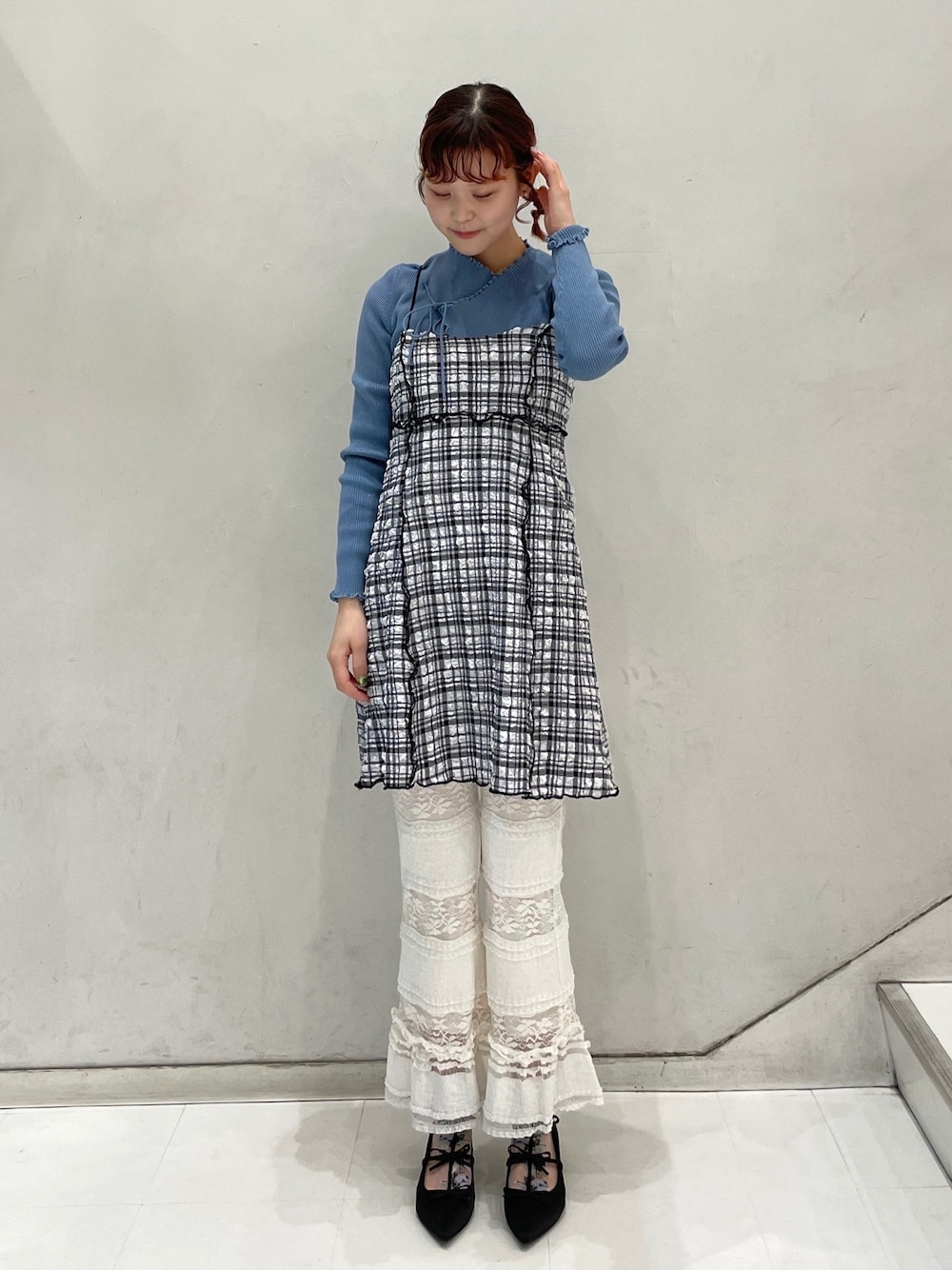 ホワイト系のスラックス、ブルー系のニット/セーター、ブラック系のワンピースを着用したレディースの冬コーディネートの1枚目の写真