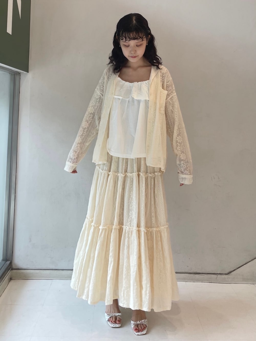 ホワイト系のスカート、ホワイト系のパンプス、ホワイト系のキャミソールを着用したレディースの夏コーディネートの1枚目の写真