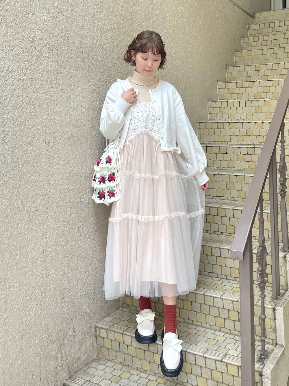 ホワイト系のニット/セーター、ピンク系のワンピース、ホワイト系のショルダーバッグを着用したレディースの冬コーディネートの1枚目の写真