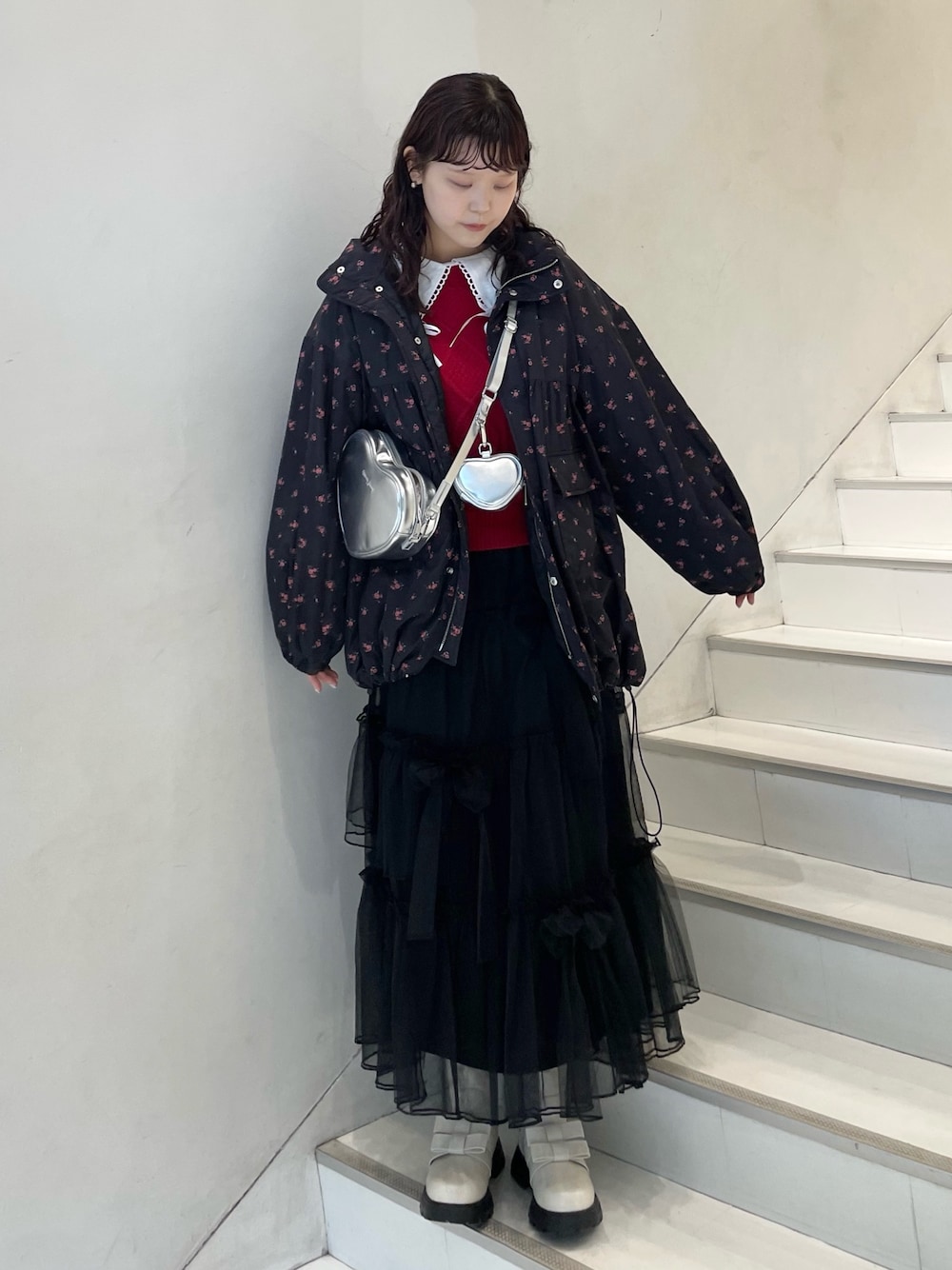 ブラック系のスカート、ホワイト系のシャツ/ブラウス、レッド系のニット/セーターを着用したレディースの冬コーディネートの1枚目の写真