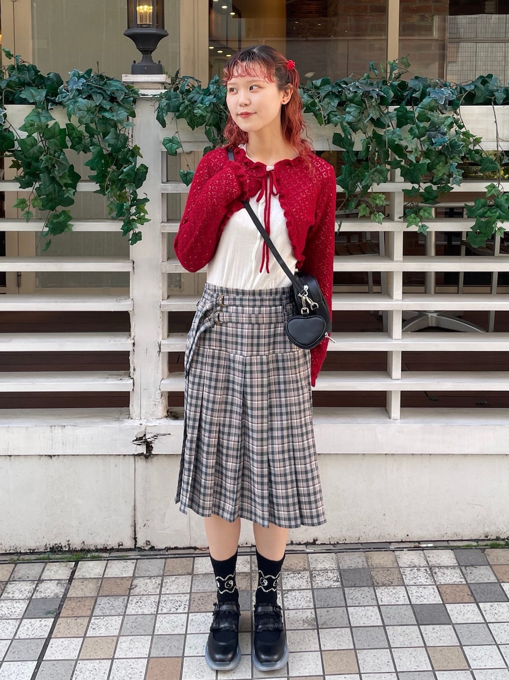 ブラック系のスニーカー、ホワイト系のTシャツ/カットソー、レッド系のカーディガン/ボレロを着用したレディースの春コーディネートの1枚目の写真