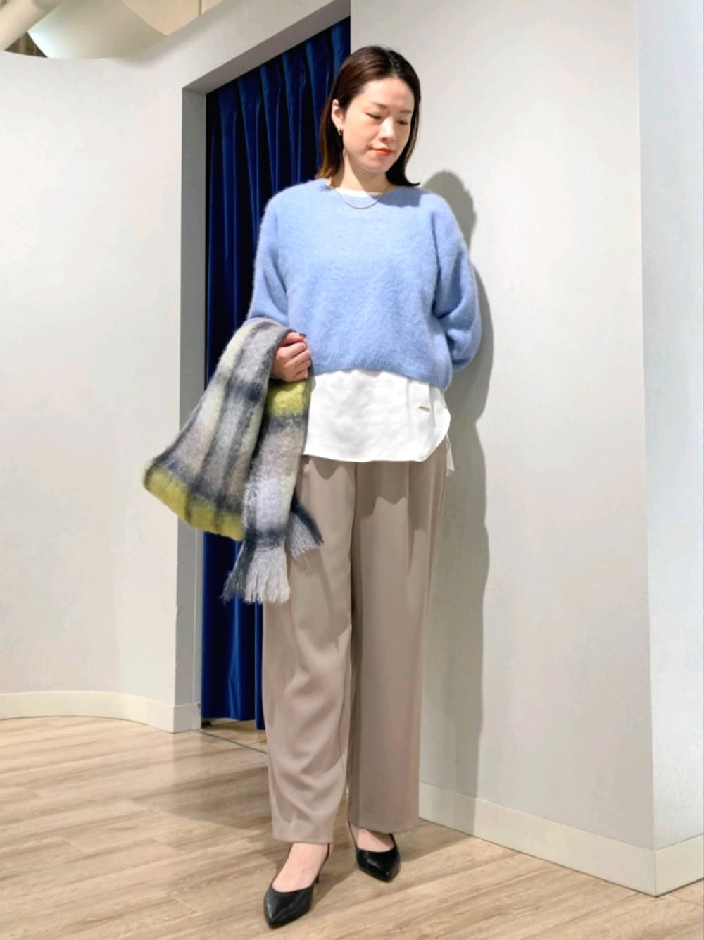 ブルー系のニット/セーター、ホワイト系のシャツ/ブラウス、ベージュ系のその他パンツを着用したレディースの秋コーディネートの1枚目の写真