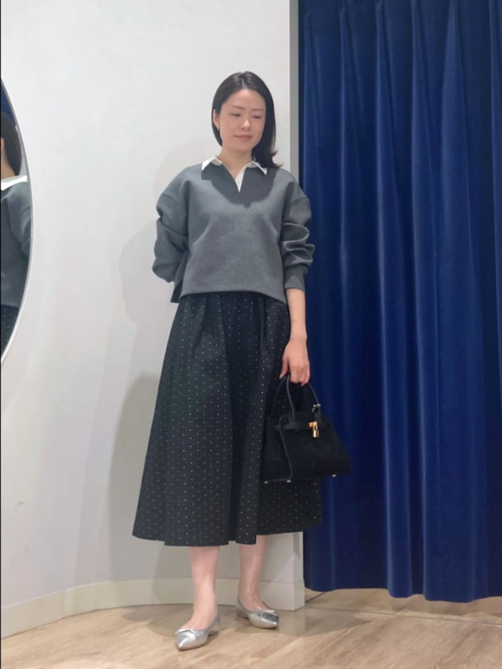 グレー系のTシャツ/カットソー、ブラック系のスカート、ブラック系のトートバッグを着用したレディースの秋コーディネートの1枚目の写真