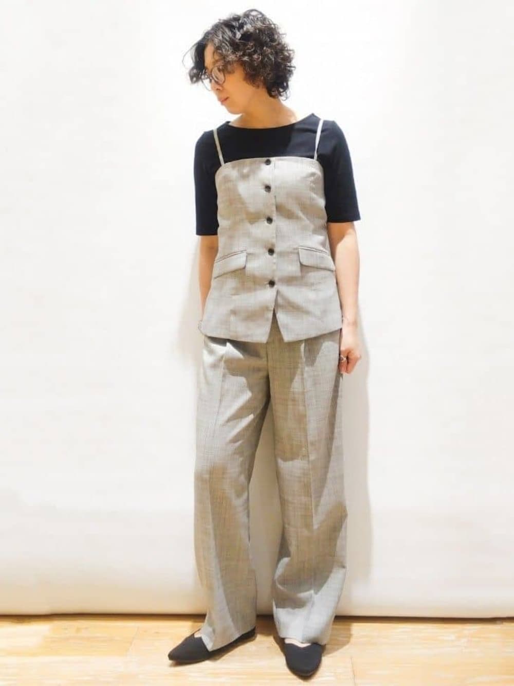 グレー系のベスト、ブラック系のTシャツ/カットソー、グレー系のその他パンツを着用したレディースの春コーディネートの1枚目の写真