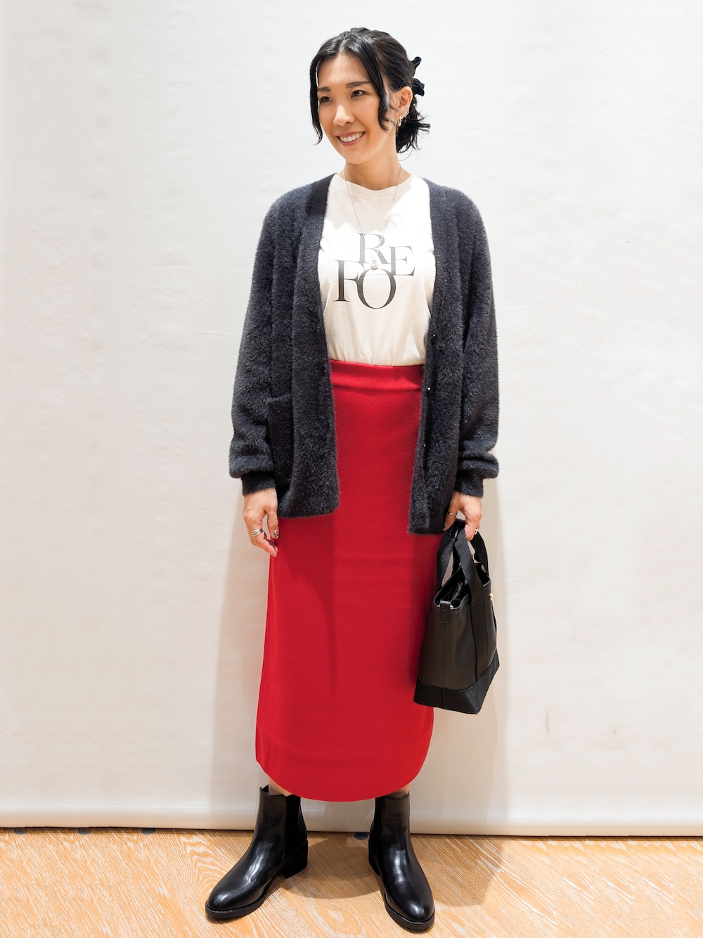 ホワイト系のTシャツ/カットソー、グレー系のカーディガン/ボレロ、レッド系のスカートを着用したレディースの秋コーディネートの1枚目の写真