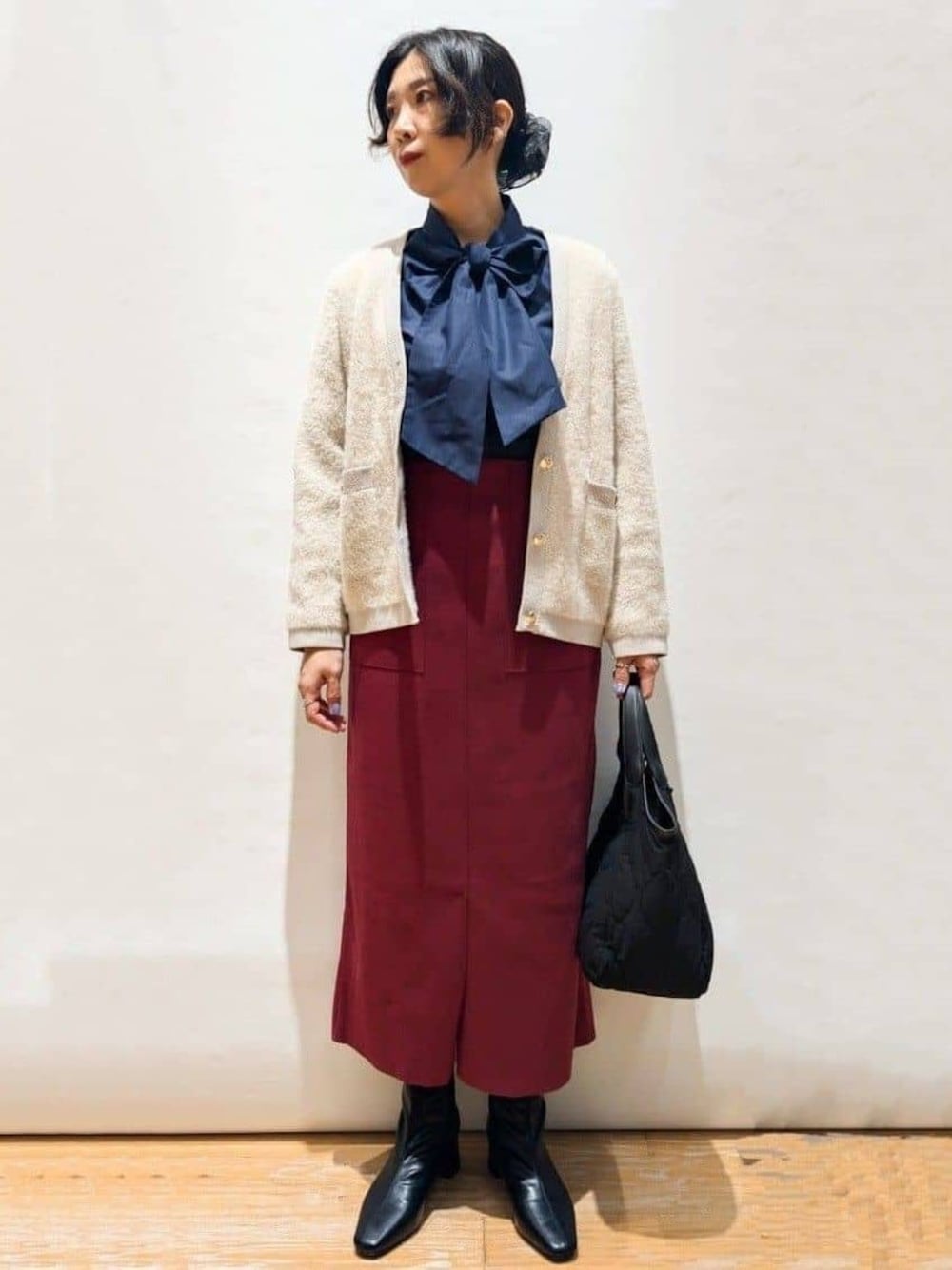 ベージュ系のカーディガン/ボレロ、ブルー系のシャツ/ブラウス、レッド系のスカートを着用したレディースの秋コーディネートの1枚目の写真
