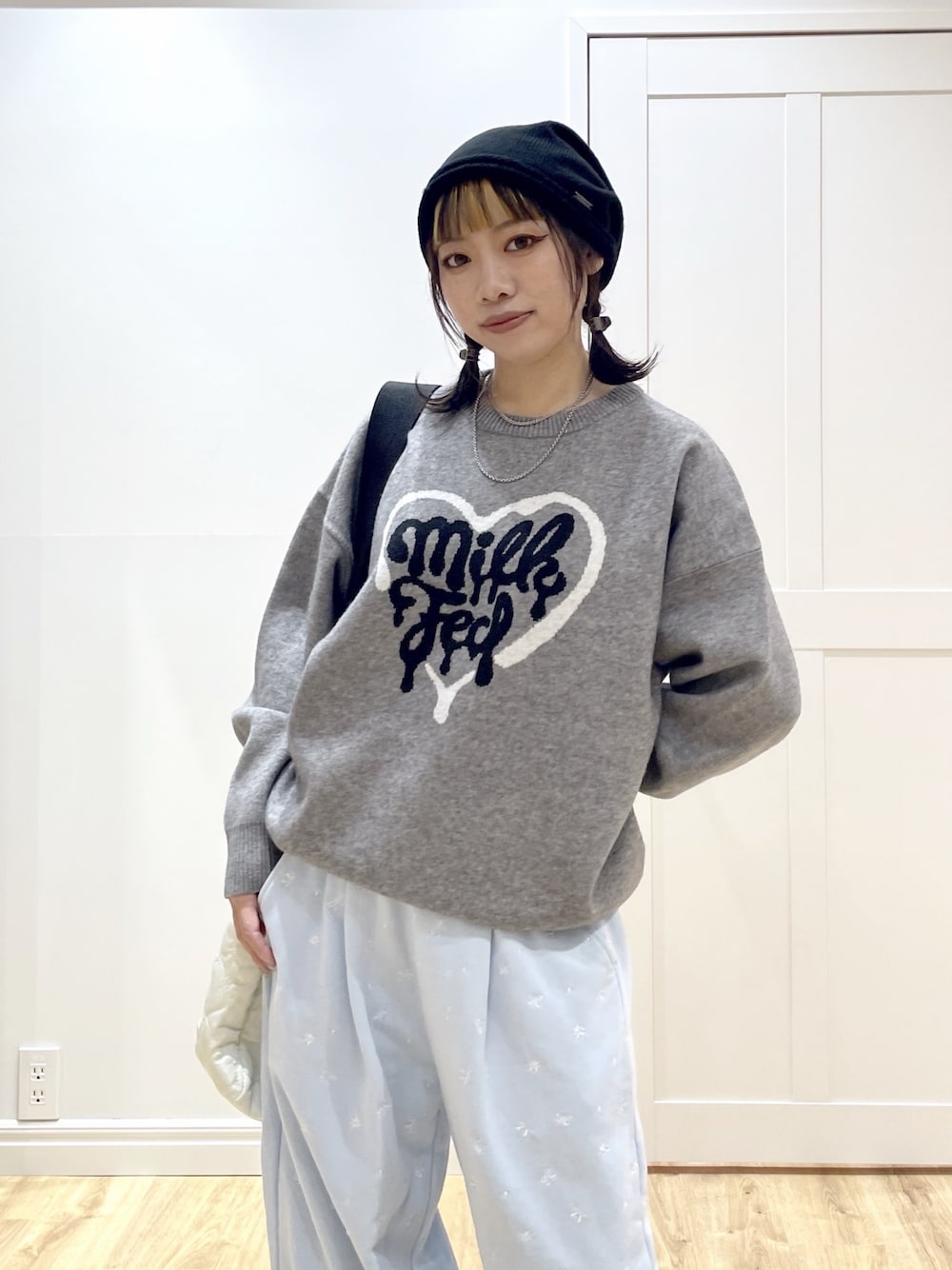 ブルー系のスウェットパンツ、グレー系のニット/セーター、ホワイト系のショルダーバッグを着用したレディースの秋コーディネートの1枚目の写真