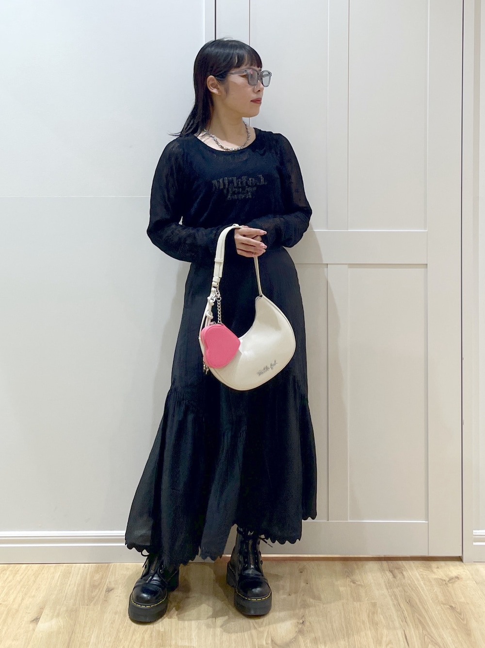 ブラック系のブーツ、ブラック系のスカート、ブラック系のタンクトップを着用したレディースの夏コーディネートの1枚目の写真