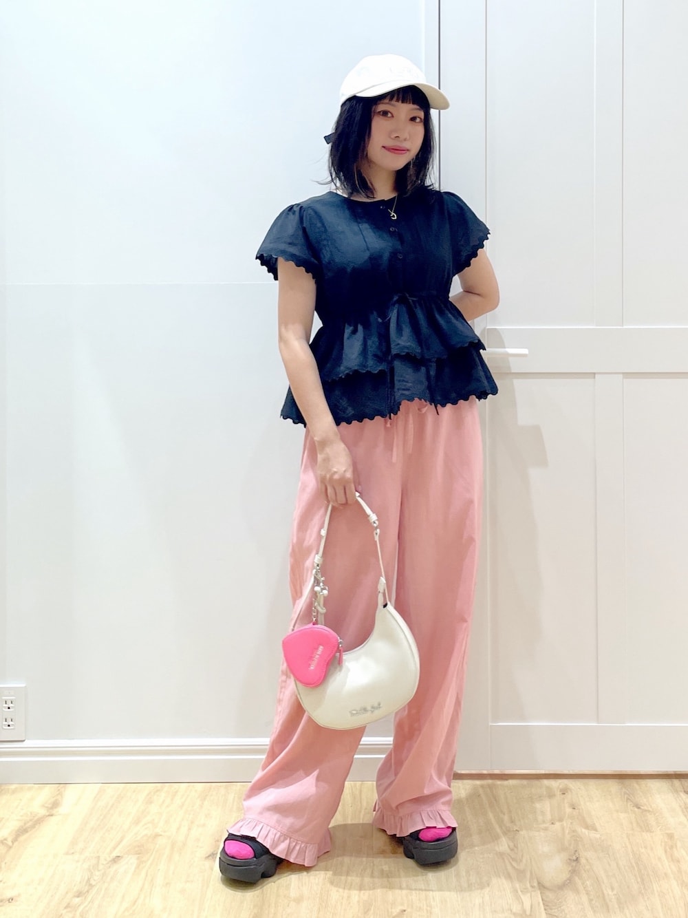 ホワイト系のハンドバッグ、ブラック系のサンダル、ブラック系のシャツ/ブラウスを着用したレディースの夏コーディネートの1枚目の写真