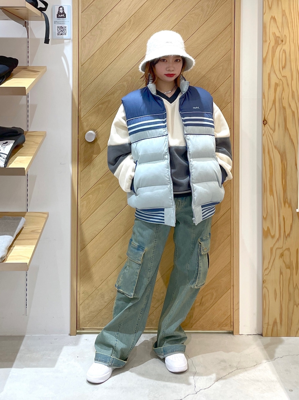 ブルー系のベスト、ブルー系のカーゴパンツ、ホワイト系のスニーカーを着用したレディースの秋コーディネートの1枚目の写真