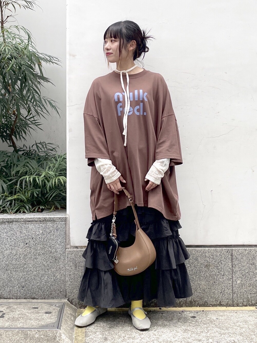 ブラック系のスカート、ホワイト系のTシャツ/カットソー、ブラウン系のTシャツ/カットソーを着用したレディースの秋コーディネートの1枚目の写真