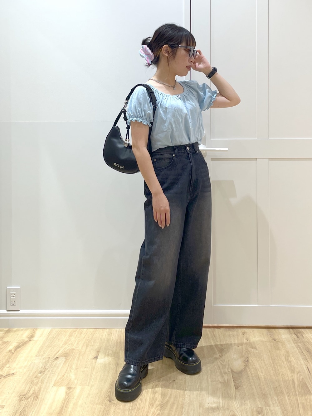 ブラック系のデニムパンツ、ブラック系のブーツ、ブラック系のハンドバッグを着用したレディースの春コーディネートの1枚目の写真