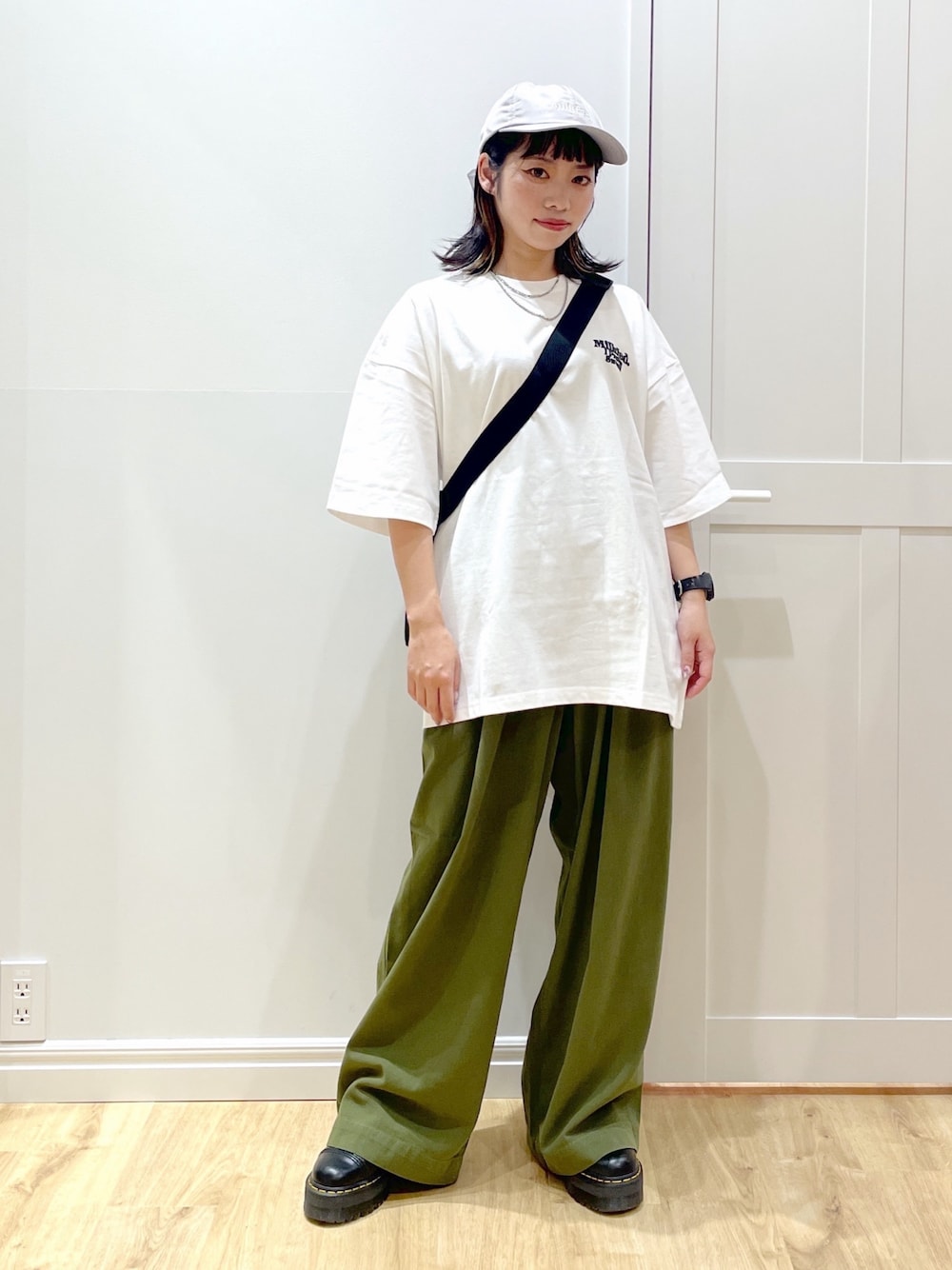 ブラック系のブーツ、グリーン系のその他パンツ、レッド系のショルダーバッグを着用したレディースの夏コーディネートの1枚目の写真