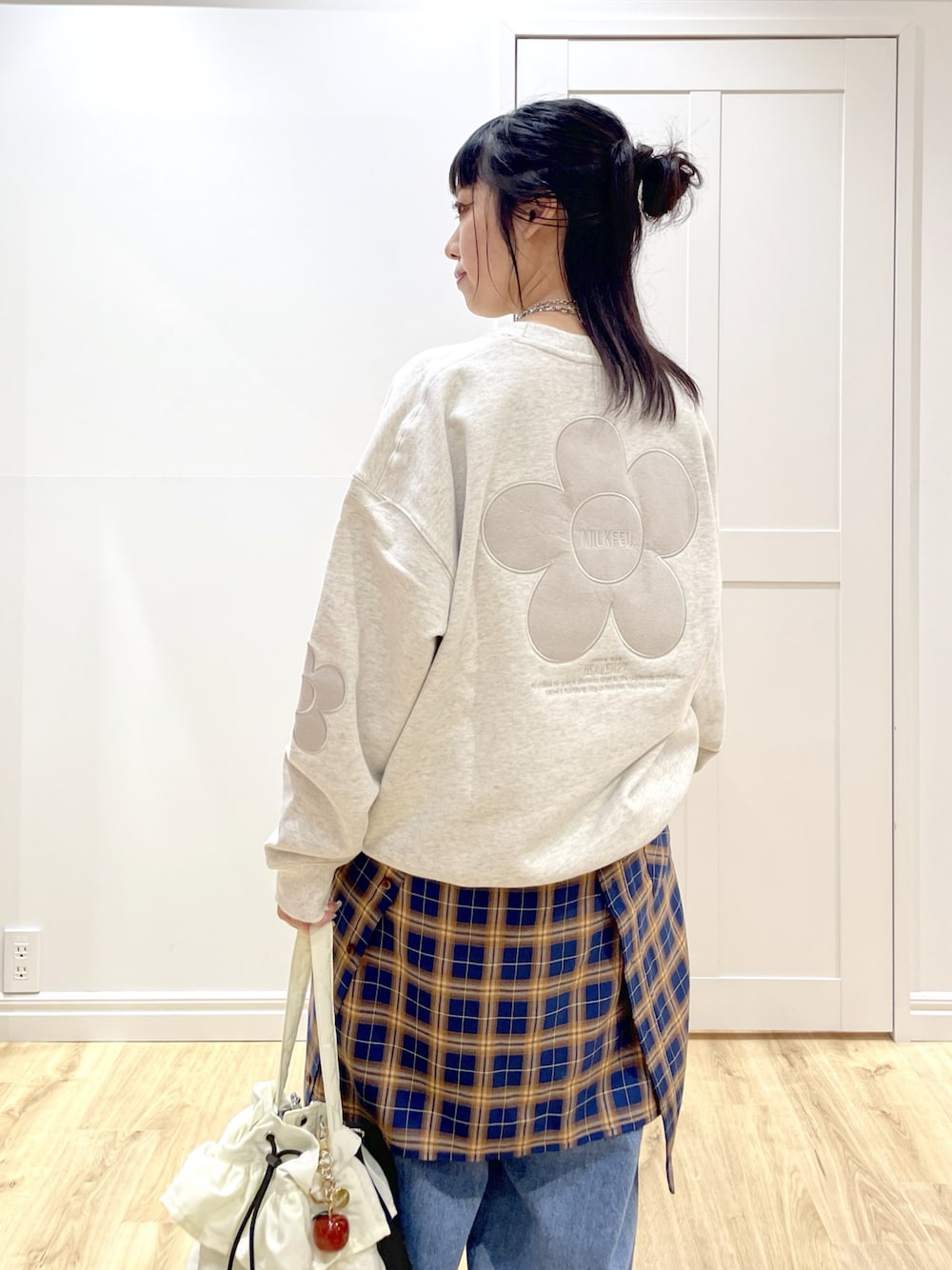 ベージュ系のスウェット、ブルー系のシャツ/ブラウス、ブルー系のデニムパンツを着用したレディースの秋コーディネートの1枚目の写真