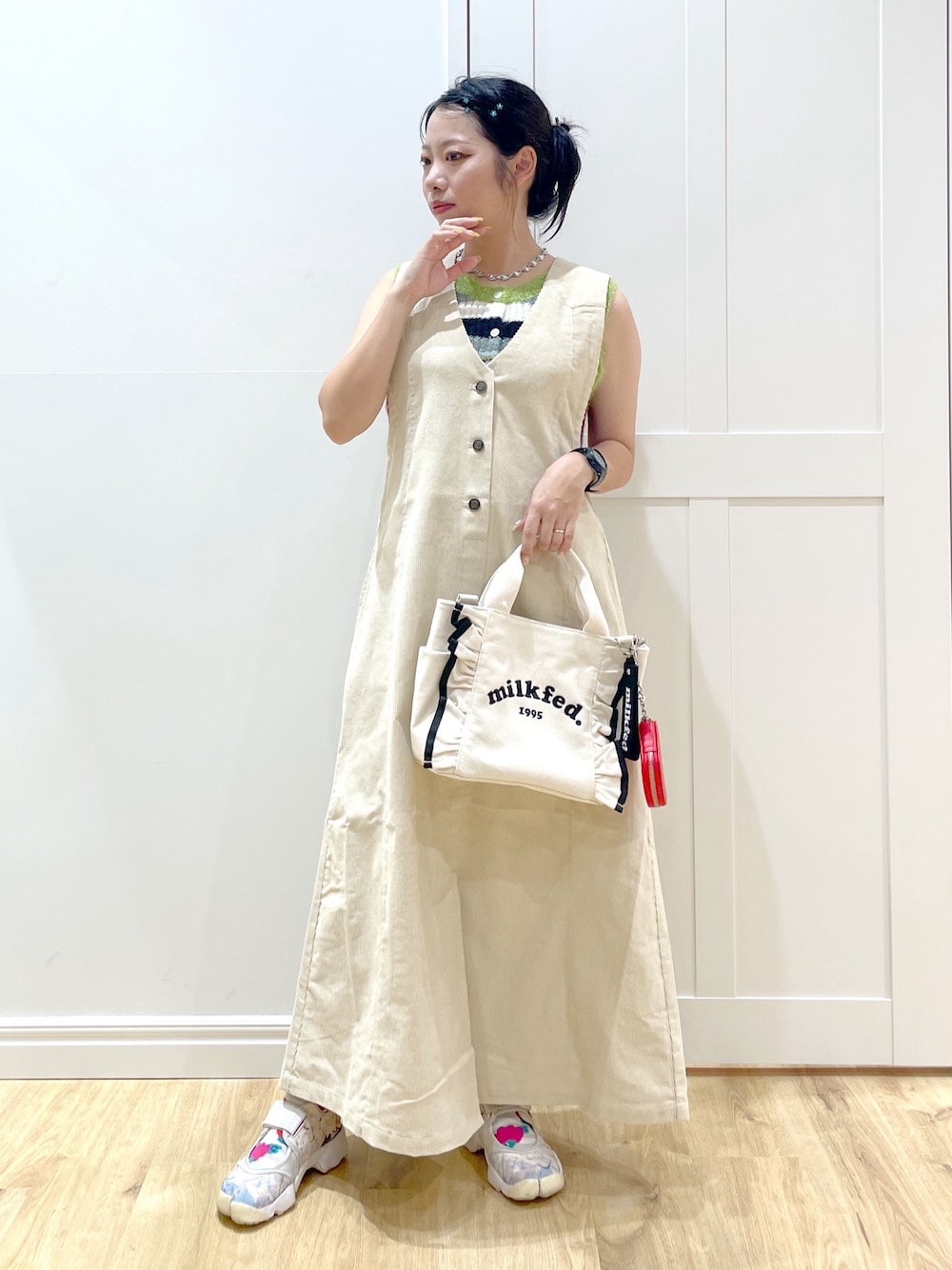 ベージュ系のワンピース、パープル系のニット/セーター、ホワイト系のショルダーバッグを着用したレディースの秋コーディネートの1枚目の写真