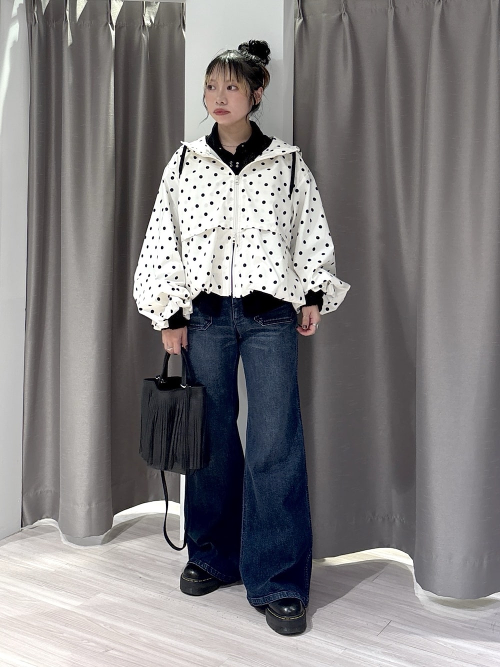 ブラック系のシャツ/ブラウス、ブルー系のデニムパンツ、ブラック系のブーツを着用したレディースの秋コーディネートの1枚目の写真