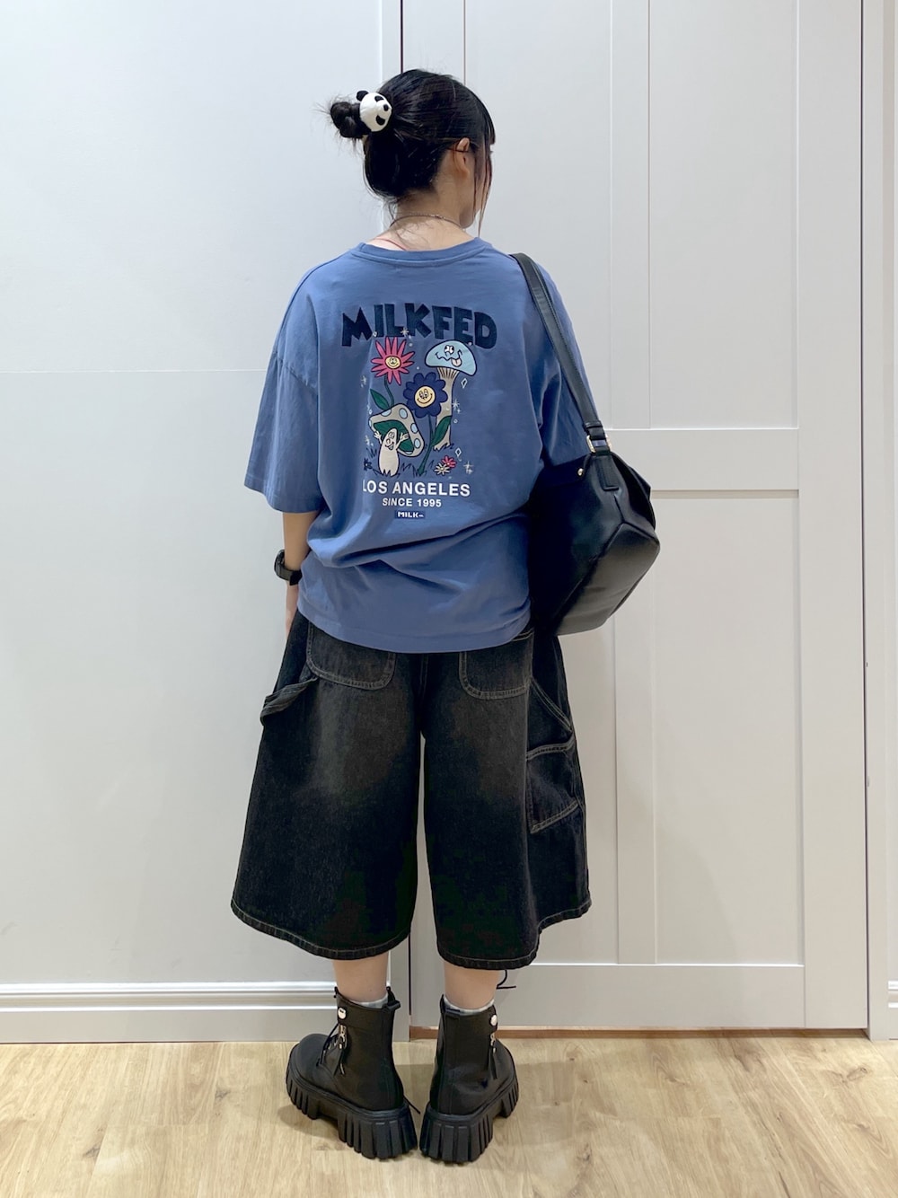 ブルー系のTシャツ/カットソー、ブラック系のデニムパンツ、ブラック系のショルダーバッグを着用したレディースの秋コーディネートの1枚目の写真