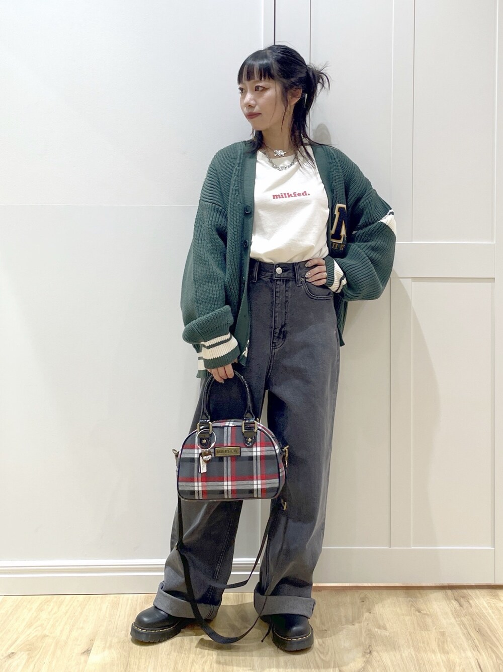 グリーン系のカーディガン/ボレロ、ホワイト系のTシャツ/カットソー、ブラック系のデニムパンツを着用したレディースの秋コーディネートの1枚目の写真