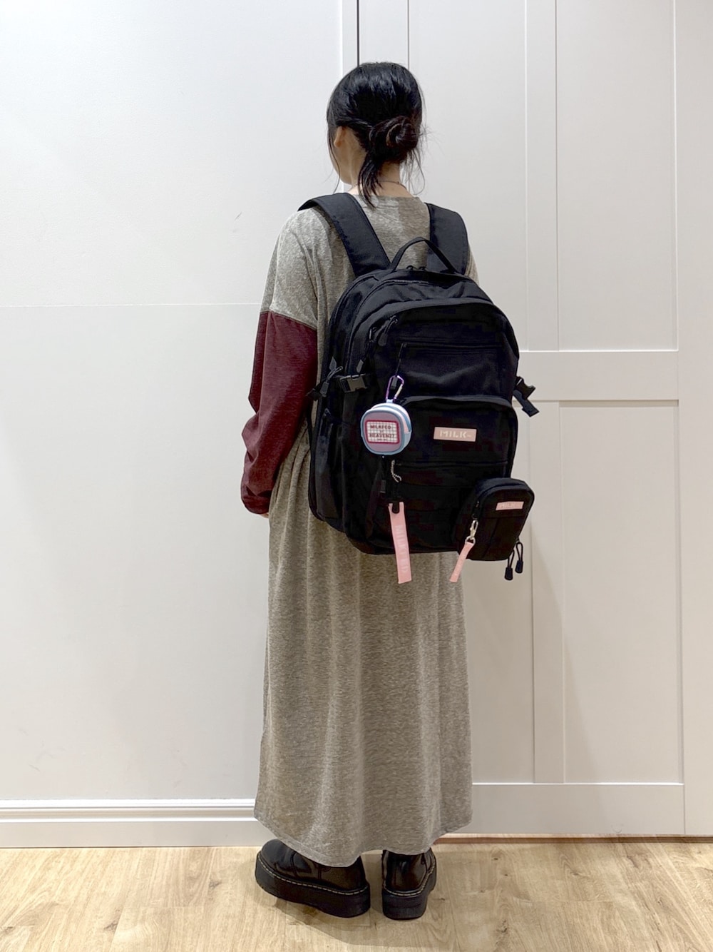 ピンク系のショルダーバッグ、ピンク系のバックパック/リュック、ブラック系のブーツを着用したレディースの春コーディネートの1枚目の写真